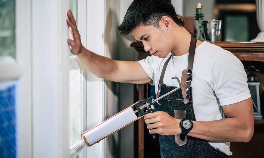 the-carpenter-holds-the-glue-and-attaches-to-the-window-.jpg
