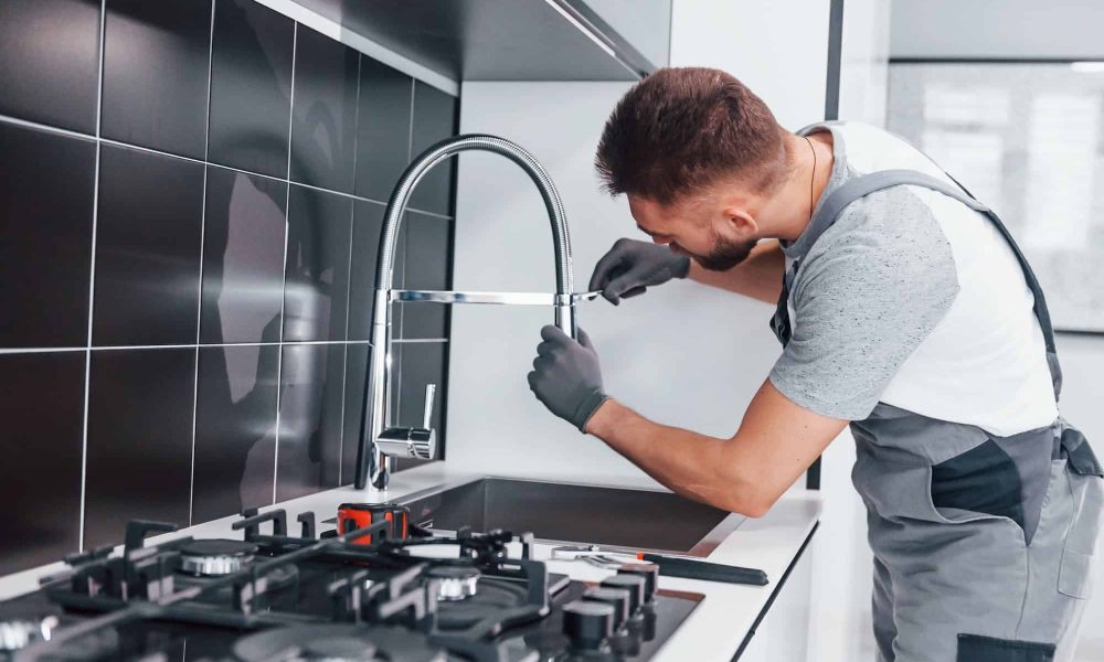 young-professional-plumber-in-grey-uniform-fixing-water-tap-on-the-kitchen-1.jpg